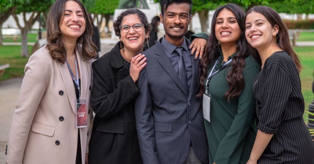 A group of diverse colleagues smiling together, showcasing teamwork and friendship outdoors.